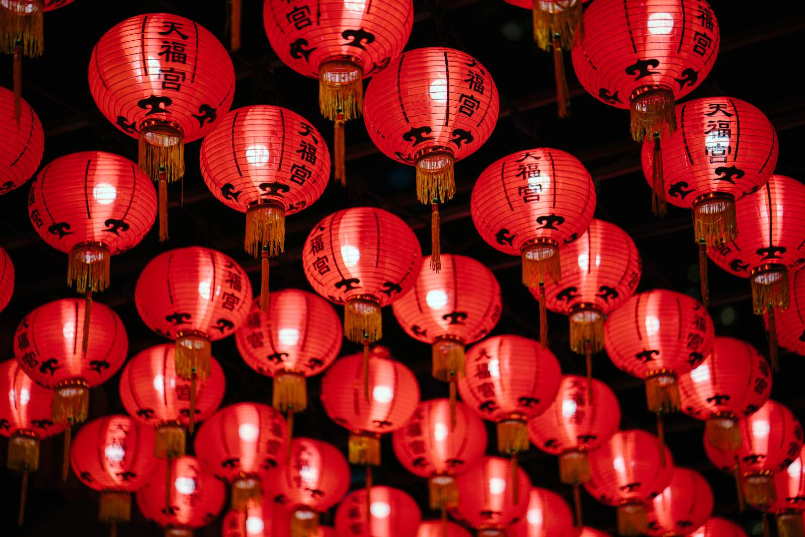 A collection of red paper lanterns with Chinese writing on them