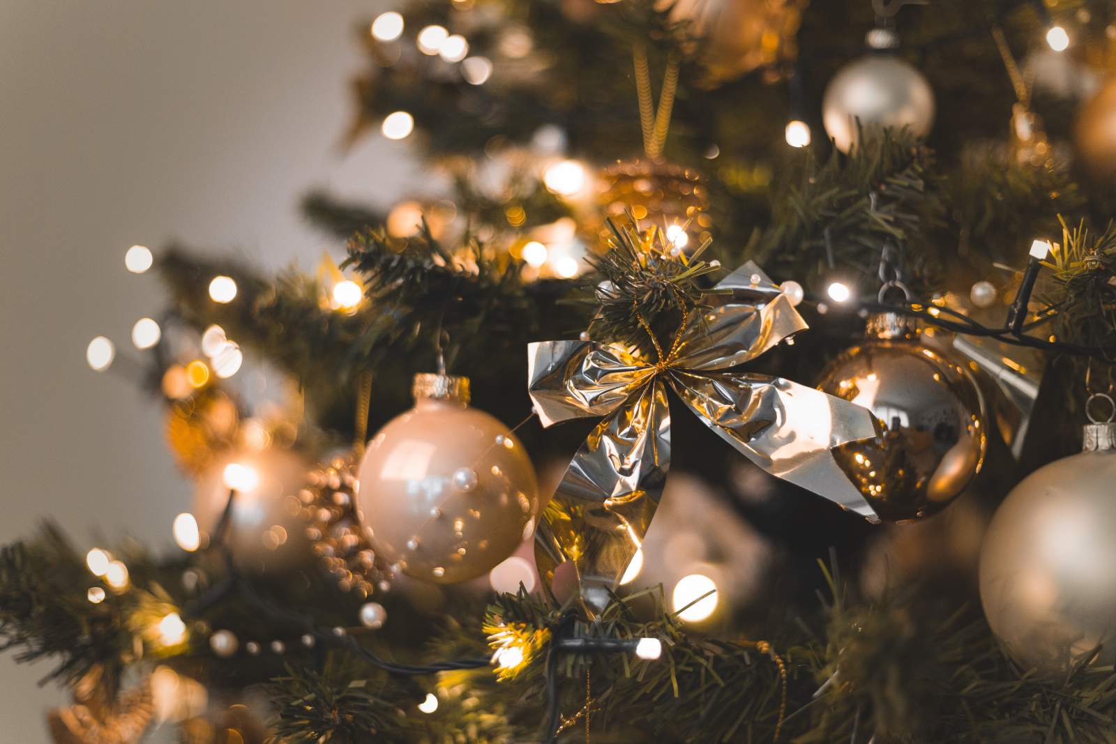A fir tree decorated with fairy lights, tinsel, and baubles