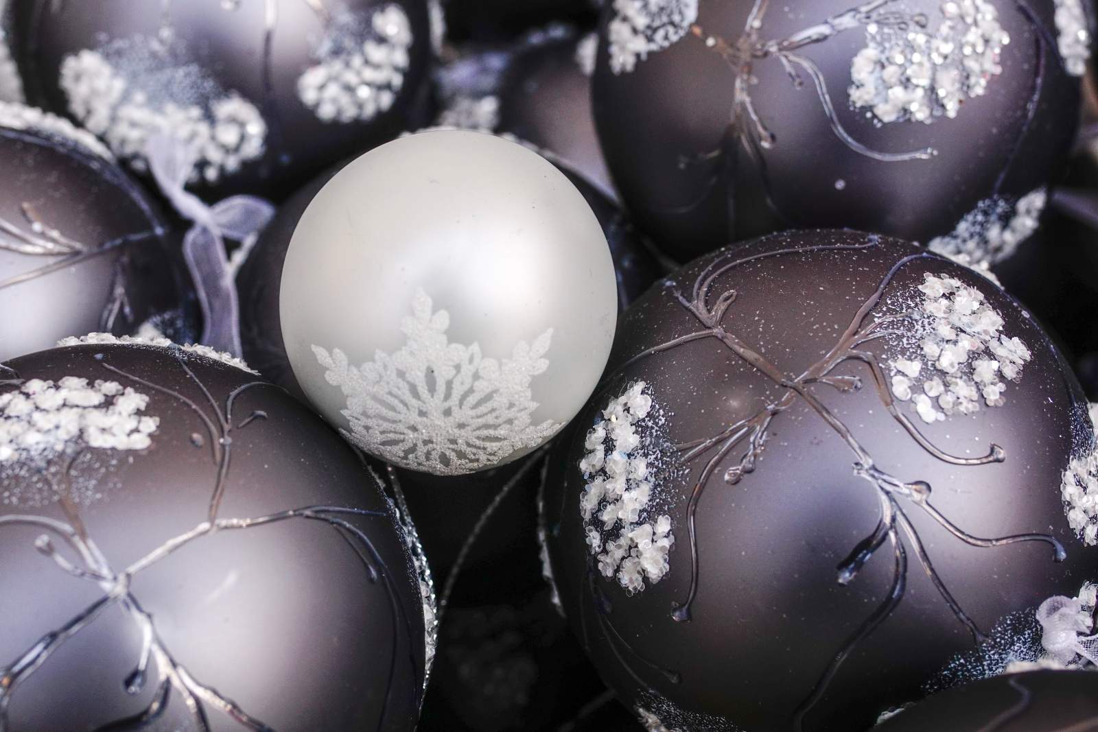 White and dark silver baubles with white snowflake designs on