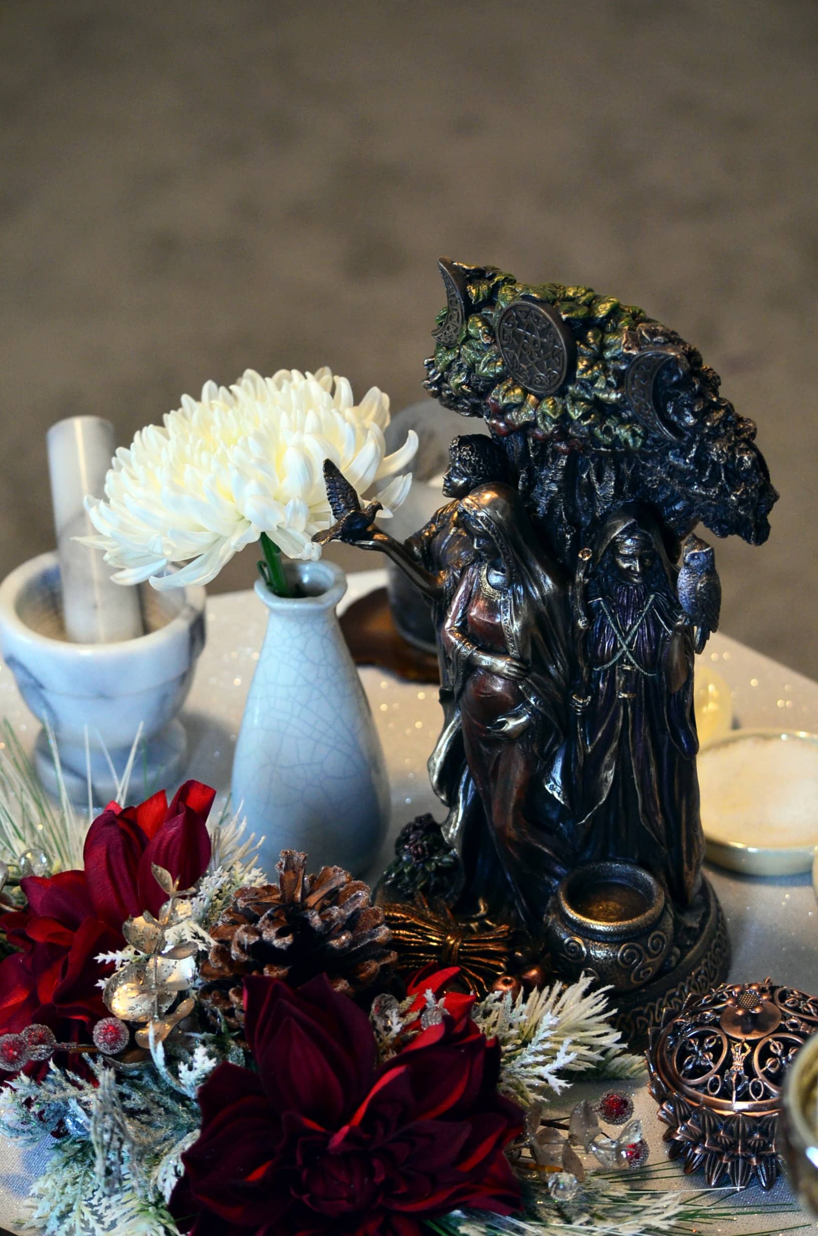 A Pagan ornament surrounded by flowers with a pestle and mortar in the background